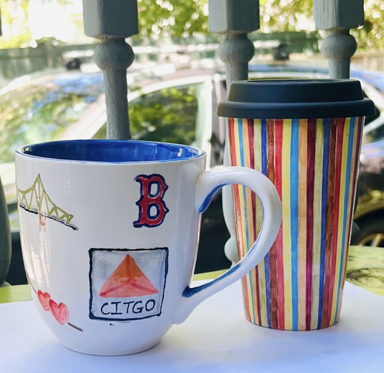 Boston-themed painted mug and colorful striped pottery