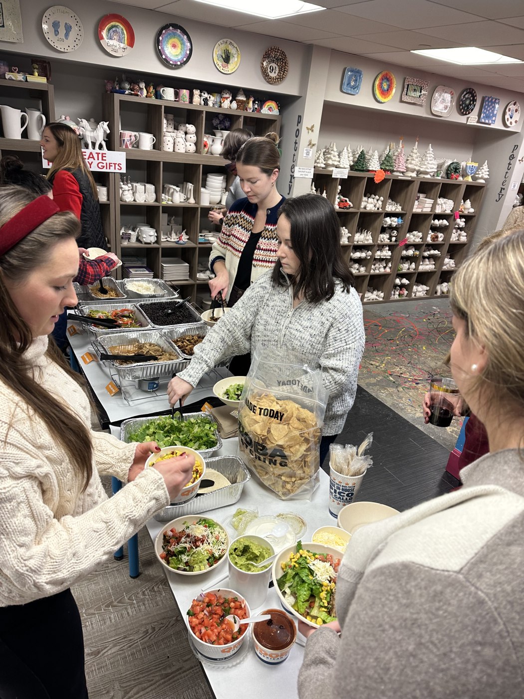 Guests sharing food and conversation around a table at The Painting Place