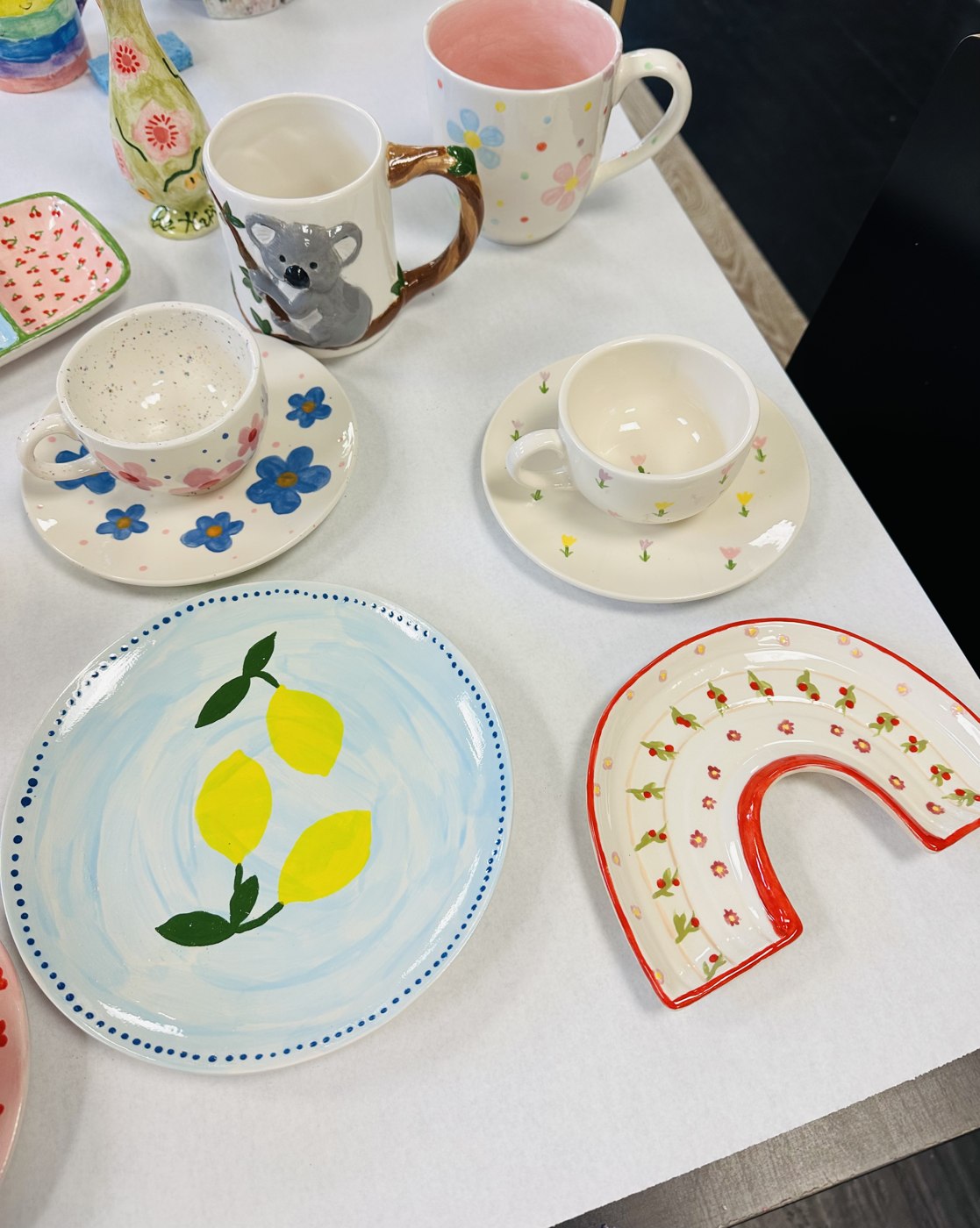 Hand-painted pottery mugs, bowls and plates with colorful designs