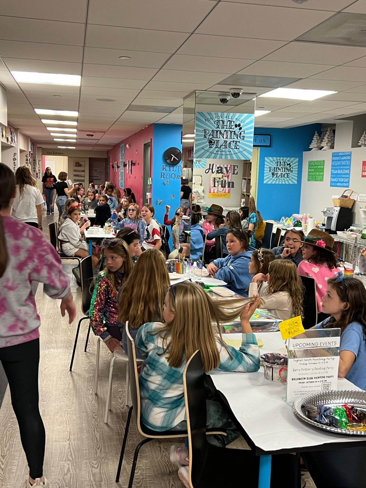 Children gathered around painting tables at The Painting Place